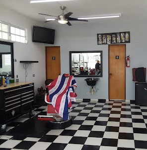 inside of marc's barber shop with black and white checkered floor tiles and a barber chair with a red and white striped towel